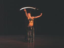 Melina performs a breath taking belly dance while balancing a sword on the tip of a dagger 1
